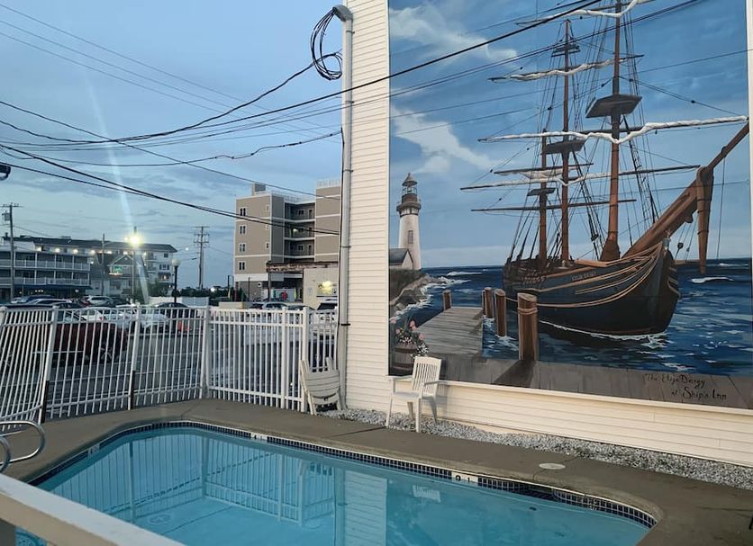 Ships Inn in Hampton pool area with lighthouse mural and sailboat artwork beside the outdoor pool