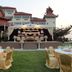 Mawlamyine Strand Hotel lawn event setup with stage, round tables, and a hotel building backdrop