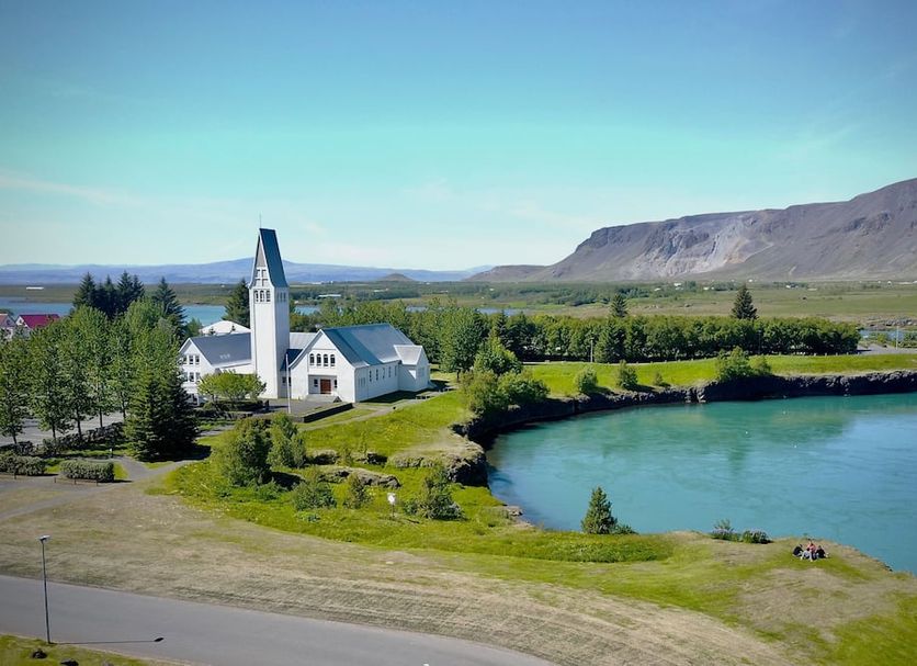 Hotel Selfoss in Selfoss with a riverside view, green grounds, and mountain backdrop