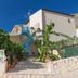 Verdemare in Macari with stone steps, tropical plants, and a blue spiral staircase outside the hotel