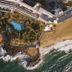 Aerial view of Hotel Fariones in Tías with oceanfront pools, palm trees, and sandy beach