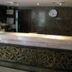 Suriwongse Hotel Bangkok reception desk with ornate carved front and wall clock