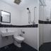Sindbad Hotel Kuala Lumpur bathroom with toilet, sink, shower, and tiled walls