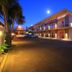 Fitzherbert Regency Motor Lodge in Palmerston North at dusk, exterior view with parking lot and palm trees