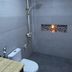 The Sunrise Huraa Huraa bathroom with shower, toilet, and mosaic wall niche