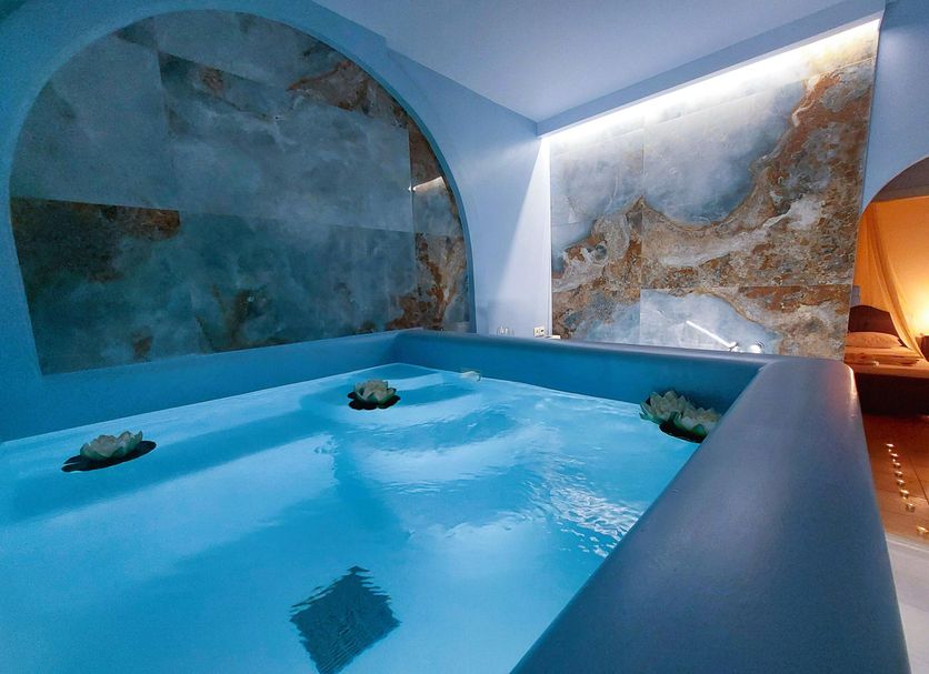Mata's Apartments Tinos indoor blue-tiled plunge pool with wall art