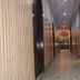 Hotel Trishul Haridwar hallway with marble floor, wood-paneled walls and ceiling lights