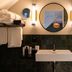 Boutique Hotel Waldhaus Birsfelden bathroom with vessel sink, round mirrors and green tile shower