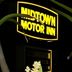 Midtown Motor Inn Whanganui illuminated sign at night framed by plants