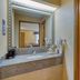 SureStay by Best Western Kansas City Country Inn North bathroom with vanity, sink, mirror, and shower curtain