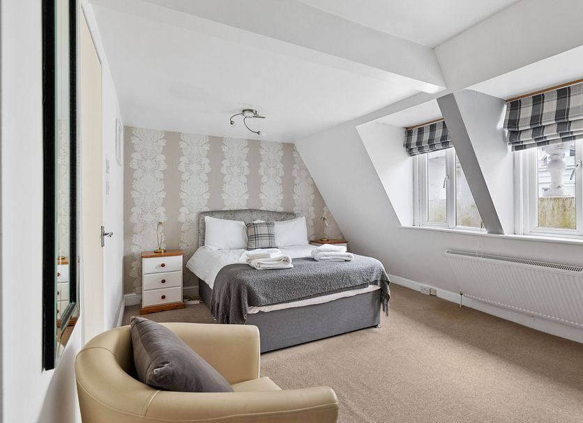 Imperial Plymouth room with double bed, armchair, and large windows in Plymouth
