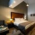 Hotel Blanca Resort & Spa in Šišava guest room with king bed, sofa, lamps, and modern wood flooring