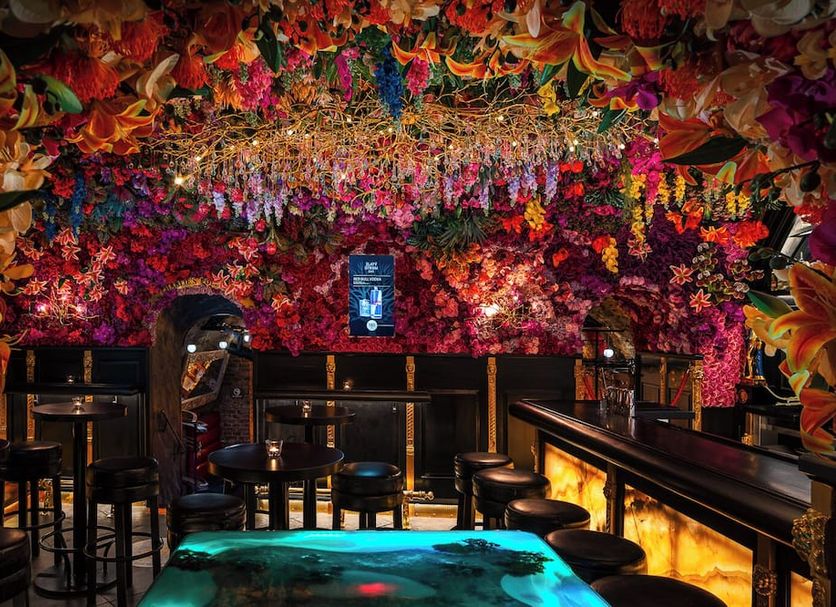 Hotel U Zlatého Stromu Prague By Bhg lounge with floral ceiling, bar seating and glowing fireplace