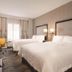 Hampton Inn Turlock guest room with two beds, desk, TV and large window