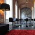 Hotel The Lodge Vilvoorde lounge with arched brick hallway, black chairs and red rug in Vilvoorde