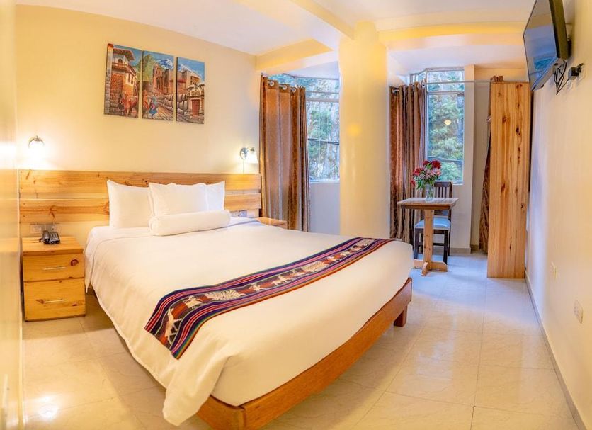 Hotel Vista Mapi in Machu Picchu guest room with bed, windows, wall art and TV