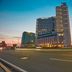 Kingsford Hotel Manila Bay in Manila at dusk, with a tall modern tower beside a wide roadway