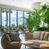 Akra V Hotel Antalya lounge with wicker chairs, beige sofa, tropical plants and sea-view windows