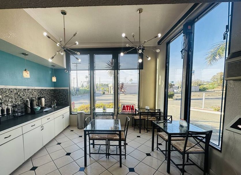 Casa Blanca Hotel in Orange breakfast area with tables, coffee station, and large windows