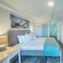 Blue Haven Holiday Apartments in Christchurch bedroom with king bed, wall-mounted TV and dresser