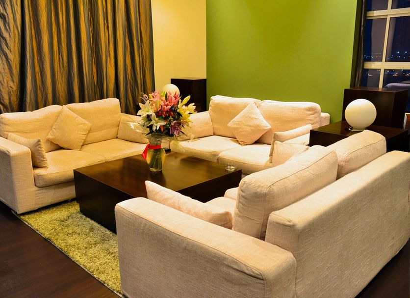 Blaire Executive Suites Manama living room with beige sectional sofas and coffee table