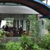 Hotel Deli River and Restaurant Omlandia in Medan shows an open-air dining terrace surrounded by lush greenery.