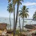The Hawaii Comforts in Panaji with palm trees and boats overlooking the sea