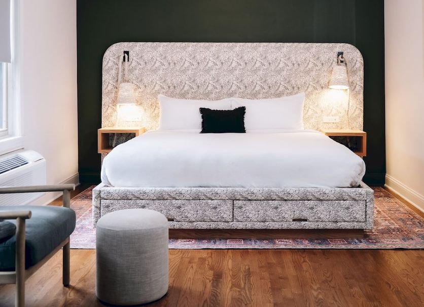 The Neighborhood Hotel Grand Beach in New Buffalo: plush bed with patterned headboard and bedside lamps