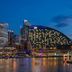 W Sydney hotel with illuminated harborfront facade overlooking Sydney waterfront at dusk