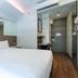 Easy Planet Bangkok Surawong guest room with bed, wall mirror, TV and compact work desk in Bangkok