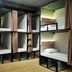 Pinx's Hostel Jakarta dorm room with stacked bunk beds, privacy curtains, and wood flooring