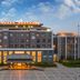 Liuhu Hotel (Hot Spring Garden Hotel) in Dezhou, front view of illuminated hotel entrance at dusk