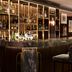 Bar at Althoff St James's Hotel & Club London in London with velvet stools and backlit bottle display