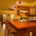 Hidden Garden Cottages & Suites in Saugatuck kitchen with orange island, bar stools, and pendant lights