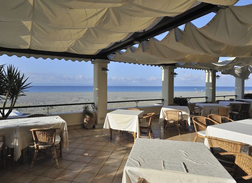 Hotel Ristorante La Lampara in Gizzeria seafront terrace with shaded tables overlooking the ocean