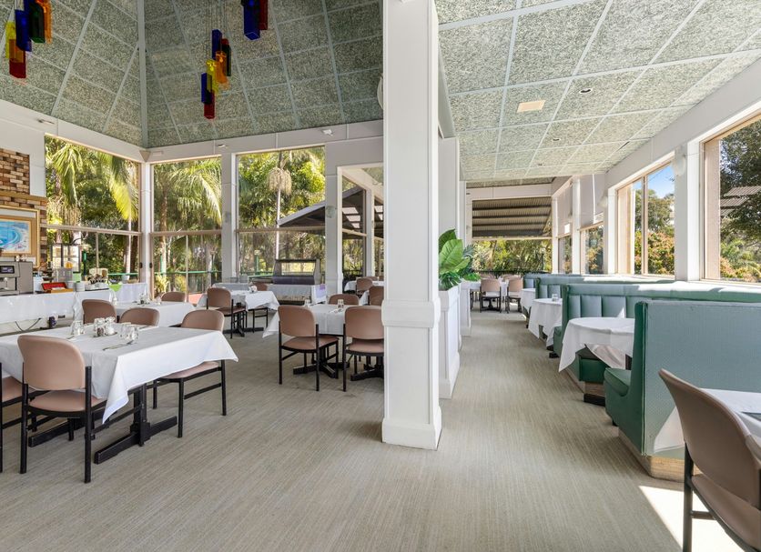 Sanctuary Resort Motor Inn in Coffs Harbour dining area with large windows and poolside seating
