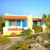 Zorbas Beach Village Hotel in Stavros, with white bungalows, red roofs and lush garden paths