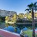 Lawhill Luxury Apartments in Cape Town with a canal, palm trees, and a large modern building