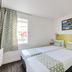 Initial By Balladins Bordeaux / Eysines twin room with lime accent wall and window in Eysines