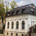 Vila Vidalis in Cluj Napoca, white historic hotel building with dark metal roof and arched windows