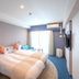 La'gent Hotel Okinawa Chatan room with two twin beds, TV, window curtains and blue carpet in Chatan