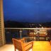 Oak Ray Heritage Hotel in Kandy balcony with wooden chairs and table overlooking city lights at dusk