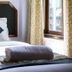 Hotel Tashi Delek in Gangtok guest room with bed, patterned pillows, and window beside curtains