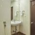 Rkn Hotel Pondicherry bathroom with wall-mounted sink, mirror, towel racks and wooden door