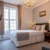 The Bedford Hotel, Tavistock guest room with king bed, window, bedside lamps and sitting chair
