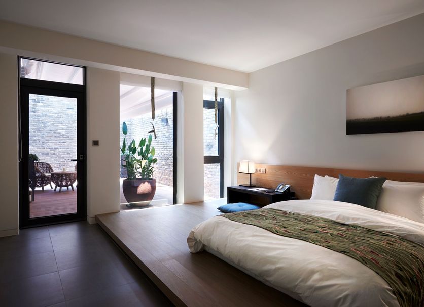 The Classic Hotel Jeonju guest room with king bed, patio doors, and outdoor seating view