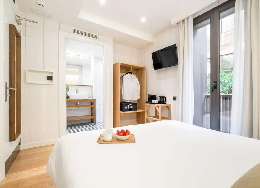 Casa Bella Gracia by Aspasios, Barcelona guest room with bed, open wardrobe and balcony doors