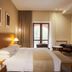 Grand Resort Jermuk guest room with king bed, seating area, and balcony doors in Jermuk
