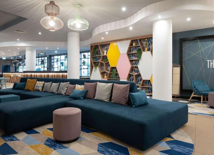 Hampton by Hilton Rome North Fiano Romano lobby with sectional seating and colorful geometric shelving