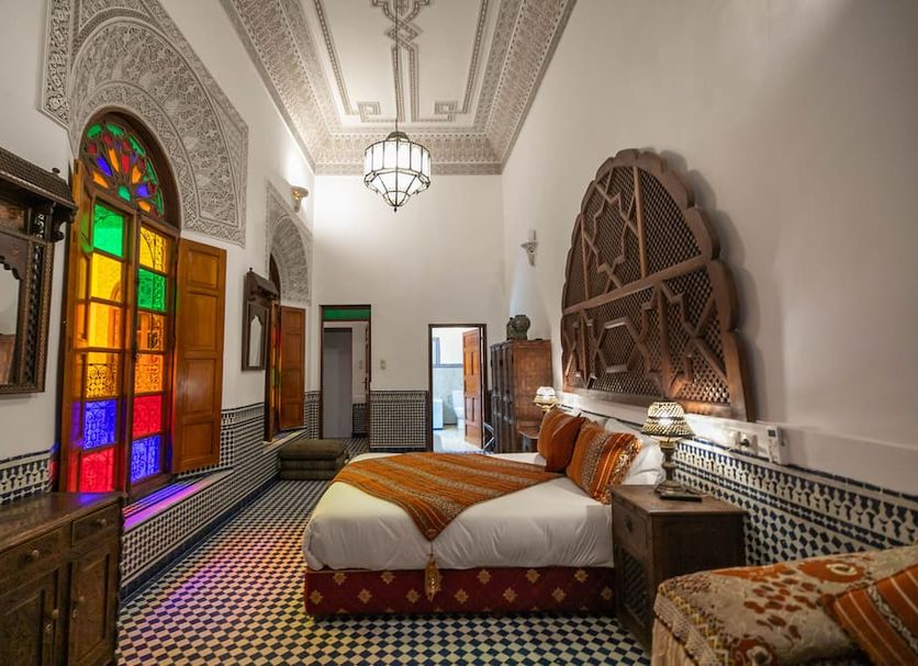 Riad La Perle De La Médina in Fez, colorful stained-glass room with twin beds and ornate ceiling